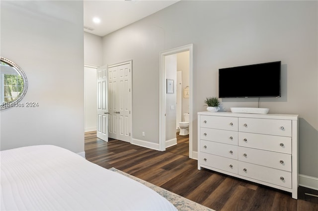 bedroom featuring ensuite bath and dark hardwood / wood-style flooring