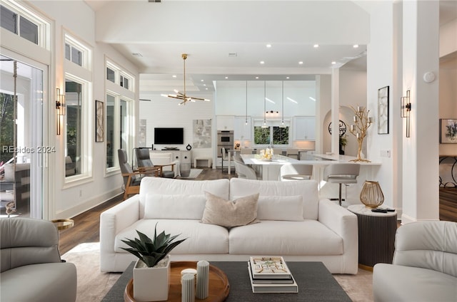 living room featuring a wealth of natural light, a chandelier, and light wood-type flooring