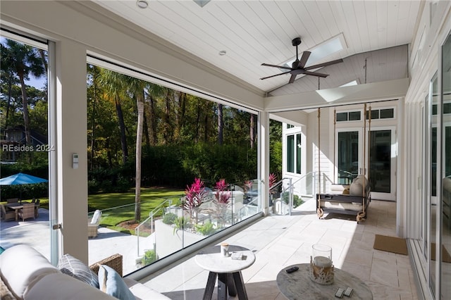 sunroom featuring wood ceiling, vaulted ceiling with skylight, and ceiling fan