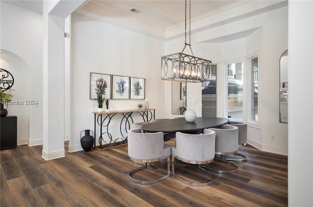 dining room featuring crown molding, dark wood-type flooring, and a notable chandelier