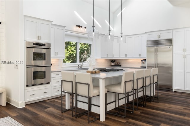 kitchen with tasteful backsplash, hanging light fixtures, a center island, and appliances with stainless steel finishes