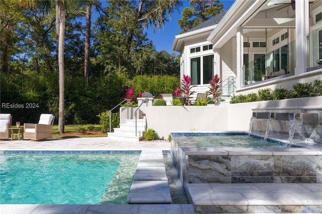 view of swimming pool featuring pool water feature, a hot tub, and a patio area