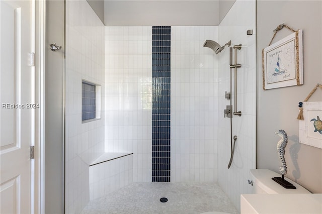 bathroom with toilet and a tile shower