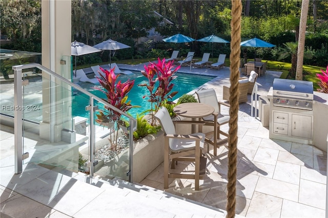 view of swimming pool featuring a grill, a patio, and exterior kitchen