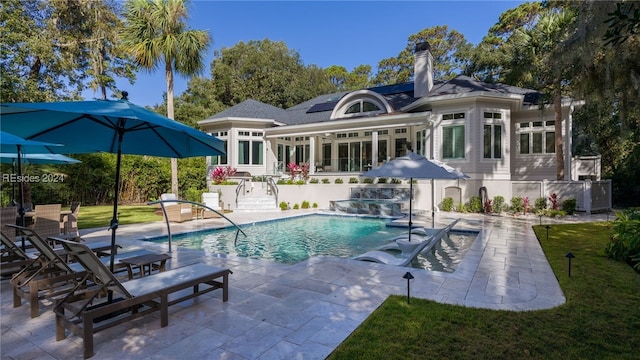 back of house featuring a patio, pool water feature, and solar panels