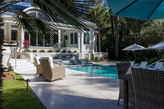 view of pool with a jacuzzi, a patio area, and pool water feature