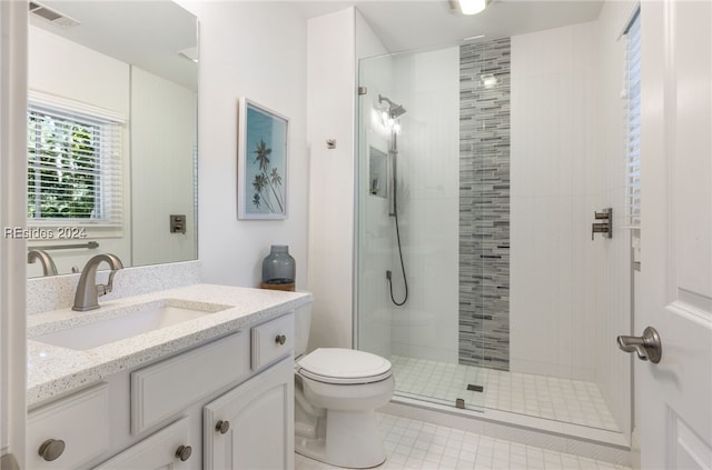 bathroom featuring vanity, tiled shower, and toilet