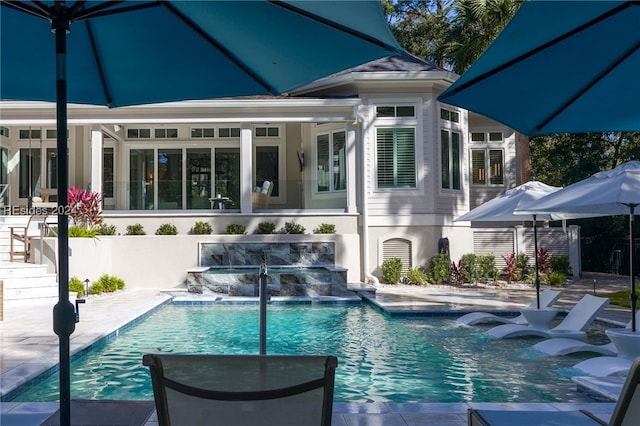 rear view of property with pool water feature and a patio area