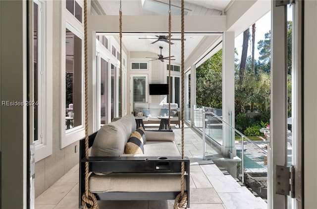 sunroom / solarium featuring ceiling fan and lofted ceiling with beams