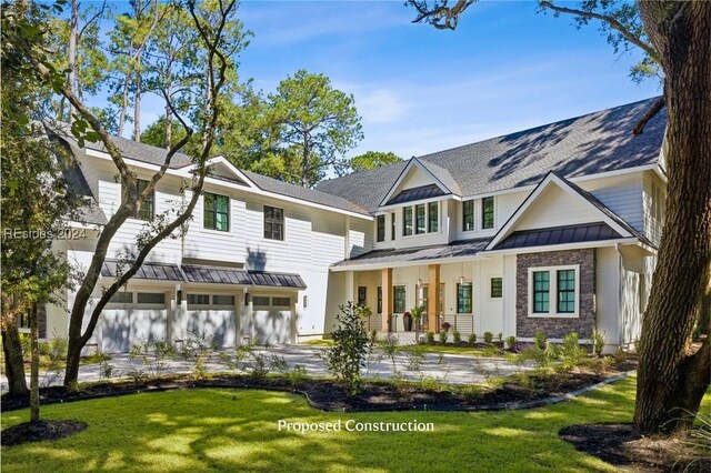 view of front of house with a garage, a front lawn, and covered porch