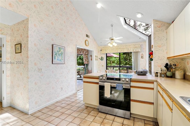 kitchen with stainless steel electric range, a skylight, white cabinets, light tile patterned flooring, and kitchen peninsula