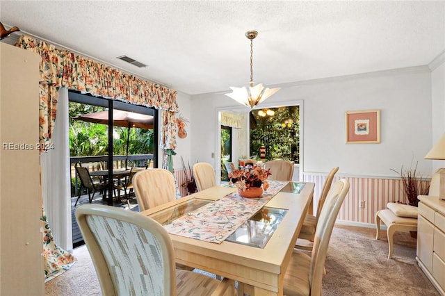 dining area featuring light colored carpet, plenty of natural light, a textured ceiling, and a notable chandelier