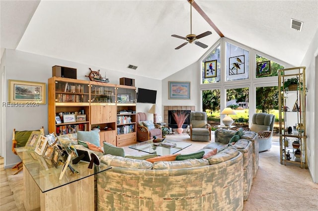 carpeted living room featuring a tile fireplace, ceiling fan, and high vaulted ceiling