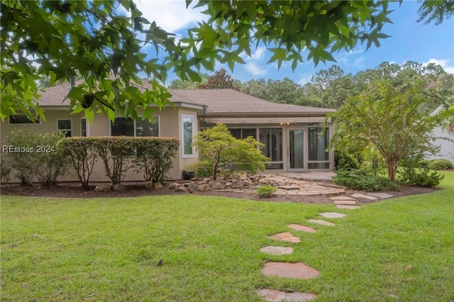 exterior space featuring a yard and a sunroom