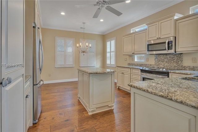 kitchen with appliances with stainless steel finishes, decorative backsplash, light stone counters, and cream cabinetry