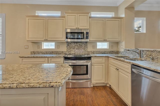 kitchen featuring cream cabinets, light stone countertops, sink, and appliances with stainless steel finishes