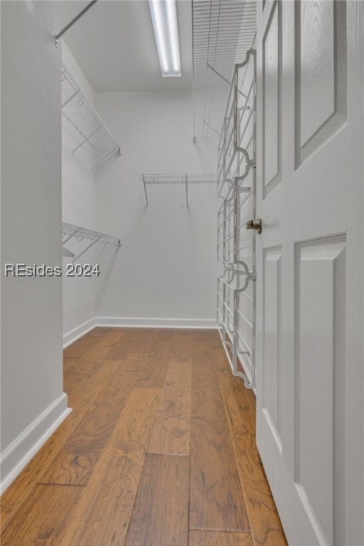 walk in closet with hardwood / wood-style flooring