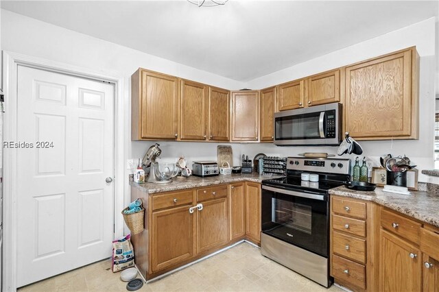 kitchen featuring light stone counters and appliances with stainless steel finishes