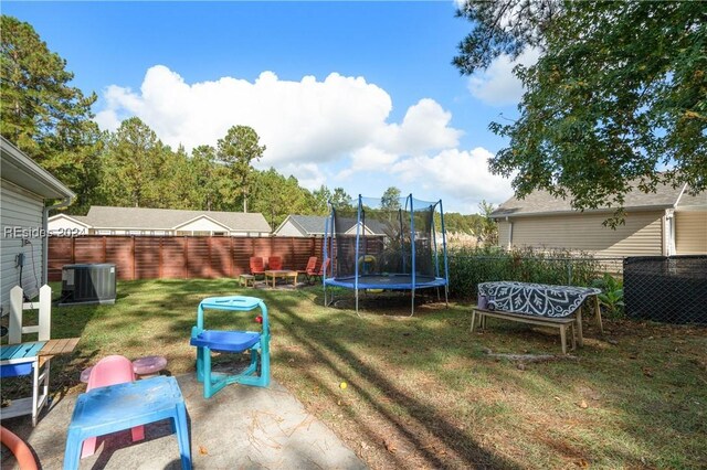 view of yard with a trampoline and cooling unit