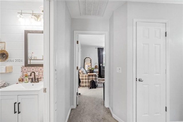 hall with light carpet and sink