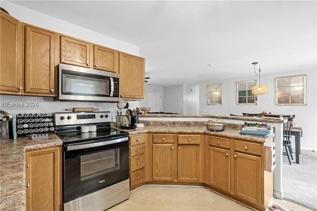 kitchen featuring pendant lighting, appliances with stainless steel finishes, kitchen peninsula, and light stone countertops