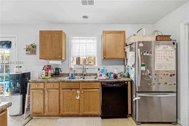 kitchen with stainless steel refrigerator, black dishwasher, and sink