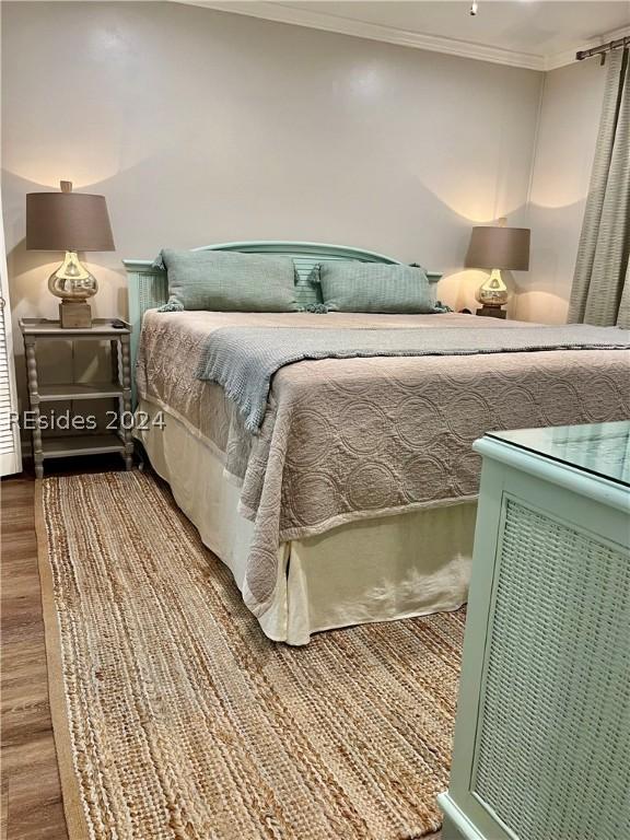 bedroom featuring hardwood / wood-style flooring and ornamental molding