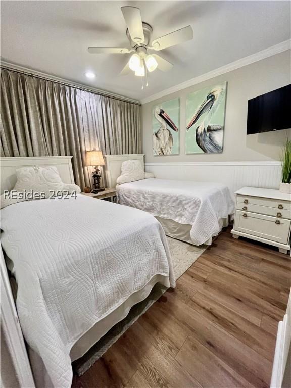 bedroom featuring hardwood / wood-style flooring, ceiling fan, and ornamental molding