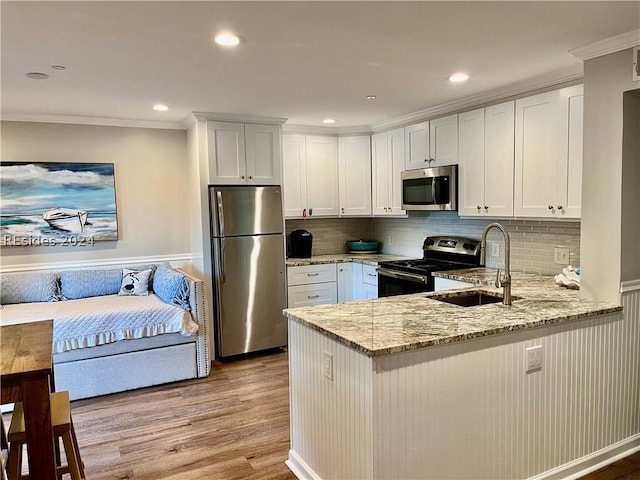 kitchen with white cabinetry, appliances with stainless steel finishes, sink, and kitchen peninsula