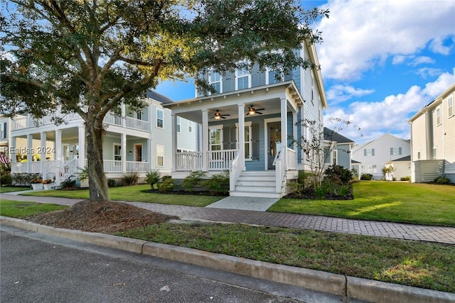 view of front of house featuring ceiling fan, covered porch, and a front yard