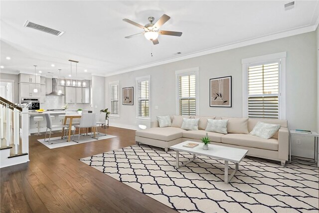 living room featuring hardwood / wood-style flooring, ceiling fan, ornamental molding, and a wealth of natural light