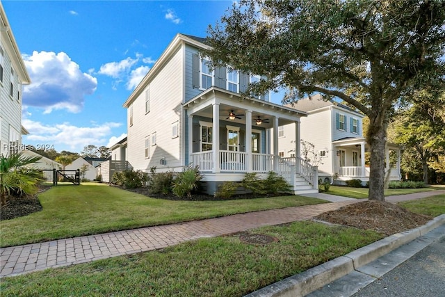 view of front of house featuring a front yard, ceiling fan, and covered porch