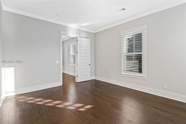 empty room featuring ornamental molding and dark wood-type flooring