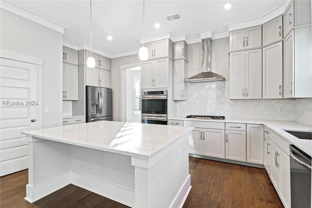 kitchen with appliances with stainless steel finishes, decorative light fixtures, decorative backsplash, light stone counters, and wall chimney range hood