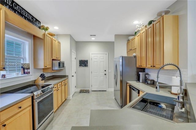 kitchen featuring tasteful backsplash, appliances with stainless steel finishes, sink, and light brown cabinetry