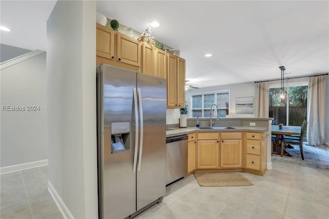 kitchen featuring light brown cabinetry, sink, appliances with stainless steel finishes, kitchen peninsula, and pendant lighting