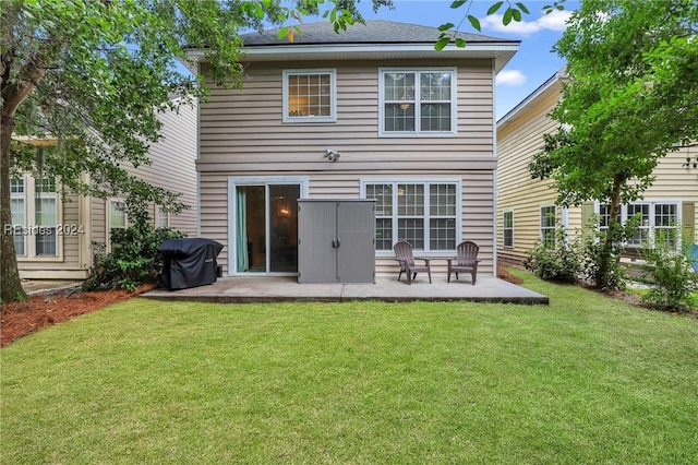 rear view of house featuring a lawn and a patio