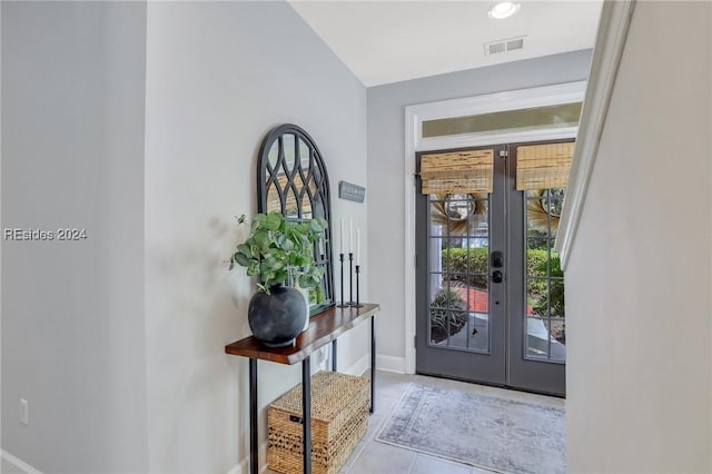 foyer entrance with light tile patterned floors and french doors