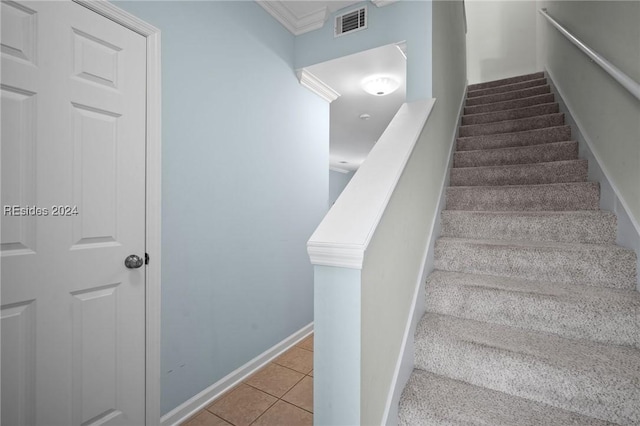 staircase featuring ornamental molding and tile patterned flooring