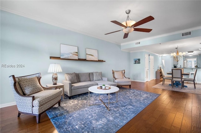 living room with crown molding, dark wood-type flooring, and ceiling fan with notable chandelier