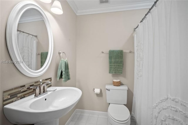 bathroom with tasteful backsplash, ornamental molding, toilet, and sink