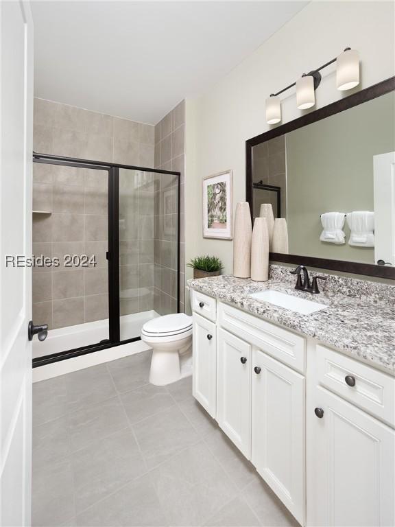 bathroom featuring vanity, tile patterned floors, toilet, and walk in shower