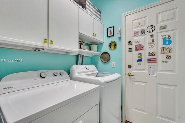 laundry area featuring washer and clothes dryer and cabinets