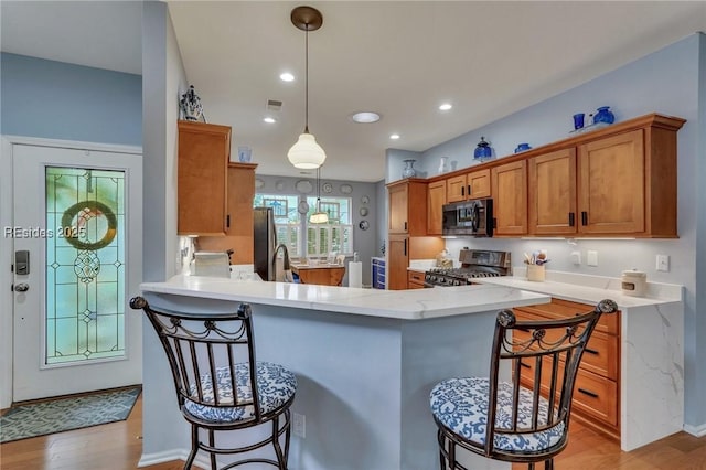 kitchen with stainless steel appliances, a kitchen breakfast bar, and kitchen peninsula