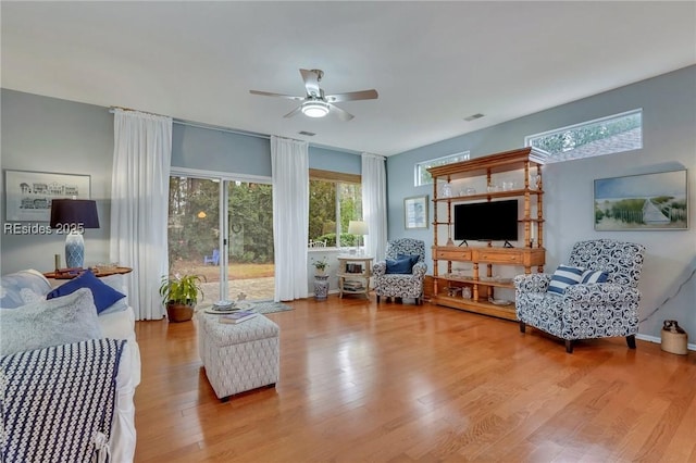 living room with ceiling fan, a healthy amount of sunlight, and light hardwood / wood-style flooring