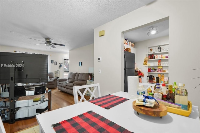 dining room featuring ceiling fan and a textured ceiling