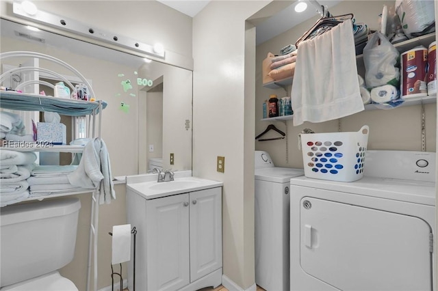 washroom with independent washer and dryer and sink