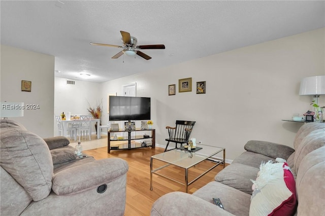 living room with wood-type flooring and ceiling fan