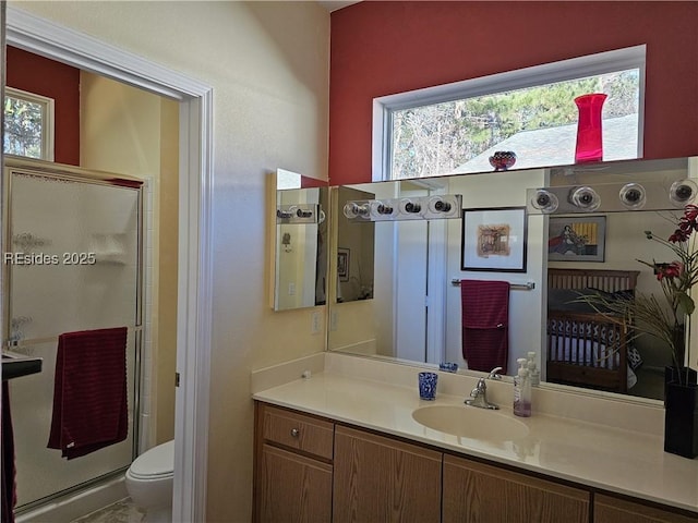 bathroom featuring vanity, a wealth of natural light, an enclosed shower, and toilet