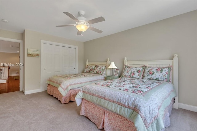 carpeted bedroom featuring ceiling fan and a closet